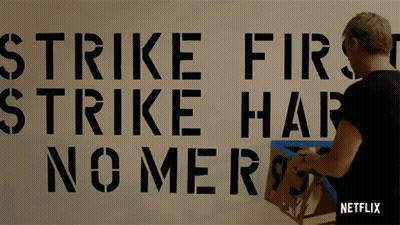 Strike First Strike Hard No Mercy Stenciled On Wall GIF