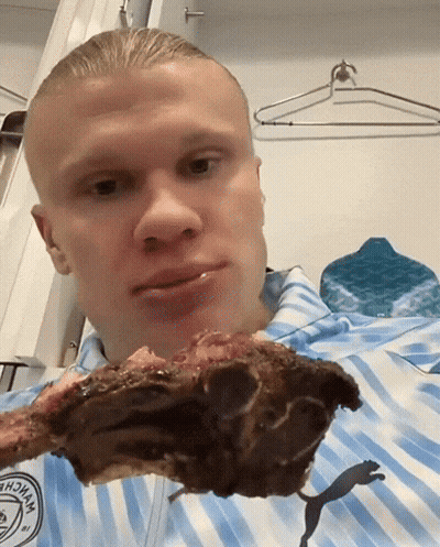 Striped Blue Shirt Man Holding Meat In Mouth GIF