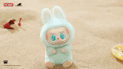 Stuffed Animal In Bunny Costume Sitting On Beach GIF