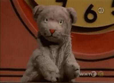 Stuffed Animal Sitting In Front Of Clock Saying Why 7 GIF