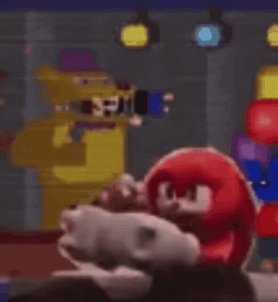 Stuffed Animal Sitting In Front Of Yellow Robot GIF