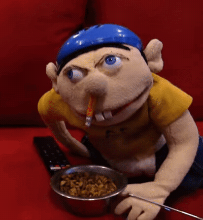 Stuffed Animal Sitting On Red Couch With Cereal GIF