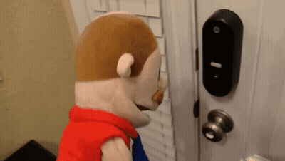 Stuffed Animal Standing In Front Of Door With Keypad GIF
