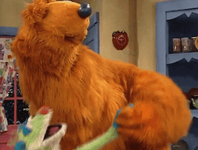 Stuffed Animal Standing On Hind Legs In Front Of Shelf GIF