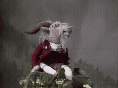 Stuffed Animal With Horns And Beard On Rock GIF