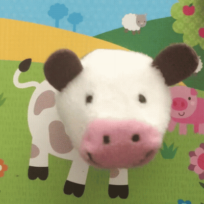 Stuffed Cow With Pink Nose Lying On Mat GIF