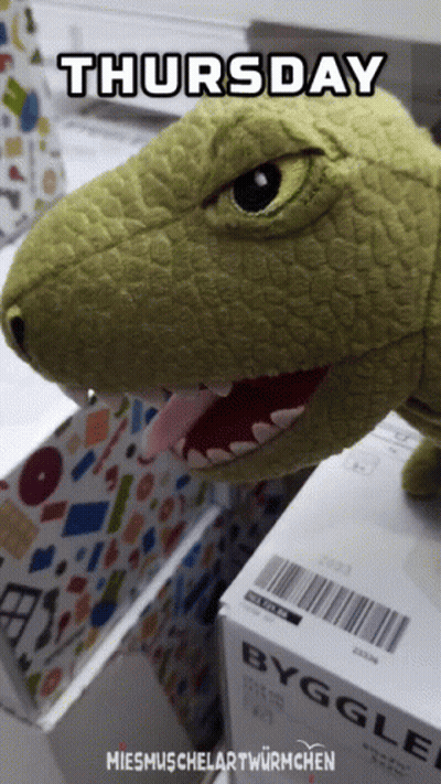 Stuffed Dinosaur Sitting On Box Saying Byggle GIF