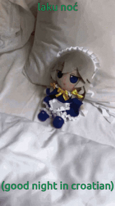 Stuffed Doll Laying On Bed Saying Good Night In Croatian GIF