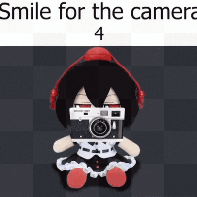 Stuffed Doll With Headphones Holding Camera Smiling GIF