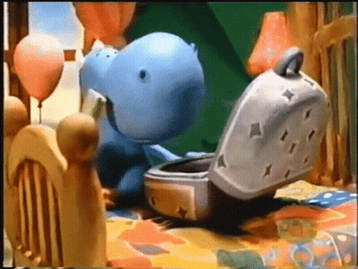 Stuffed Hippo Sitting On Bed Next To Toaster GIF