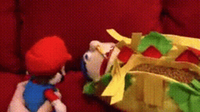 Stuffed Mario On Red Couch With Stuffed Hot Dog GIF