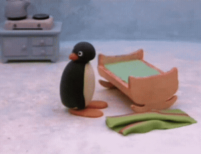 Stuffed Penguin Next To Rocking Cradle GIF