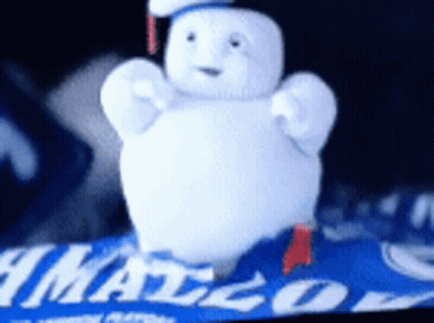 Stuffed Snowman Sitting On Blue Blanket With Mango GIF