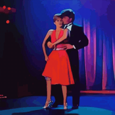 Suit-And-Tie Man Dancing With Woman In Red Dress GIF