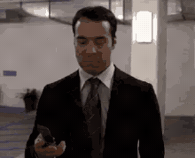 Suit And Tie Man Holding Phone Walking GIF