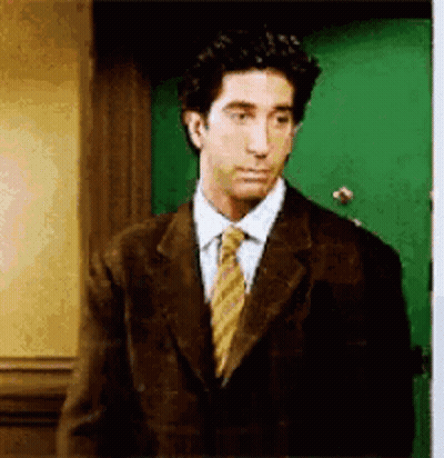 Suit Man Near Green Door Looking At Camera GIF