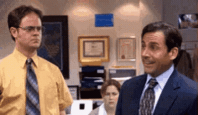 Suited Man Next To Man In Yellow Shirt GIF