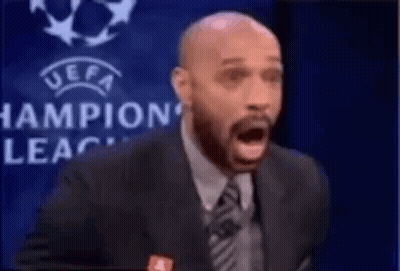 Suited Man Speaking Into Microphone With Champions League Logo GIF
