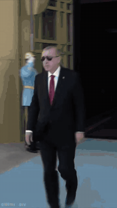 Suited Man Walking on Blue Carpet, Masked Man Behind