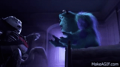 Sulley From Monsters Inc Is Sitting On A Bed Talking To A Man . GIF