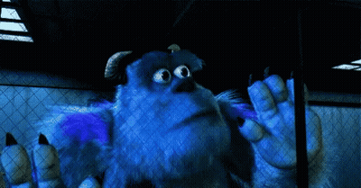 Sulley From Monsters Inc Is Standing In A Dark Room With His Hands Outstretched . GIF