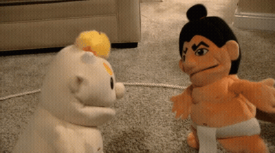 Sumo Wrestler Puppet Standing Next To Another Puppet GIF