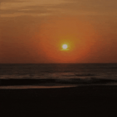 Sun Setting Over Ocean Waves GIF