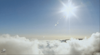 Sun Shining Over Clouds And Mountains GIF