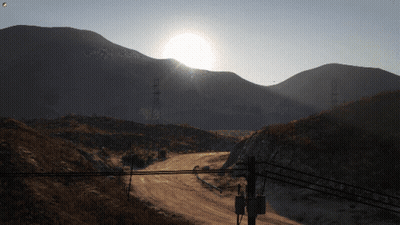 Sun Shining Over Mountains And Power Lines GIF