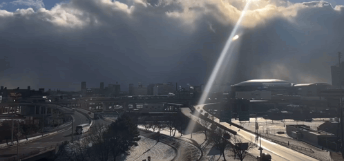 Sun Shining Through Clouds Over City GIF