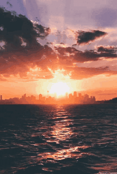 Sunset Over Ocean With Distant City GIF