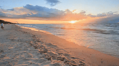 Sunset Over Ocean With Person Walking On Beach GIF
