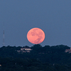 Super Moon Disappearing Behind Peaks GIF