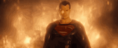 Superman Is Standing In Front Of A Fire And Looking At The Camera . GIF