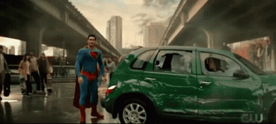 Superman Is Standing In Front Of A Green Car That Has Been Damaged GIF
