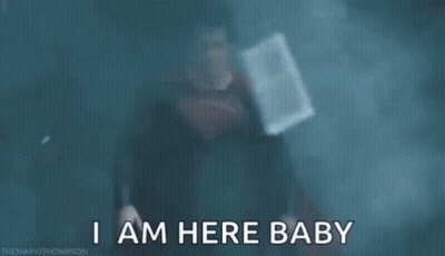 Superman Standing In Dark Room Saying I Am Here Baby GIF