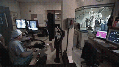 Surgeons Operating On Patient In Operating Room With Clock GIF