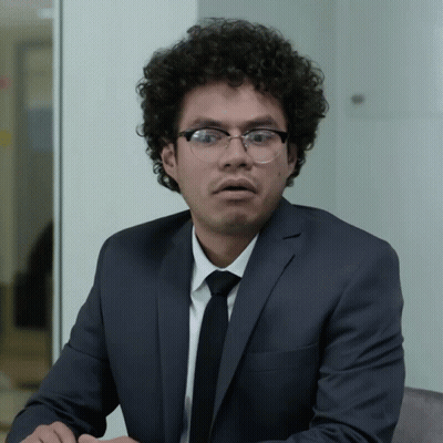 Surprised Man With Curly Hair And Glasses In Suit GIF
