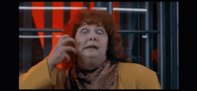 Surprised Red-Haired Woman In Yellow Jacket And Scarf GIF