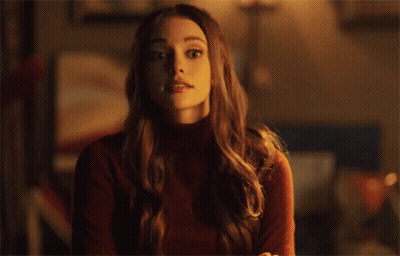 Surprised Woman In Red Sweater Looking At Camera GIF