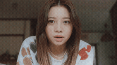 Surprised Woman In White Sweater With Flowers GIF