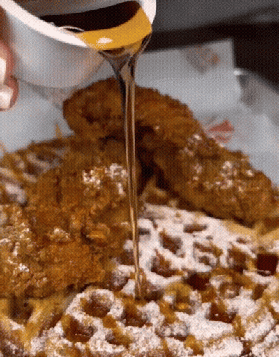 Syrup Is Poured Over A Waffle With Powdered Sugar GIF