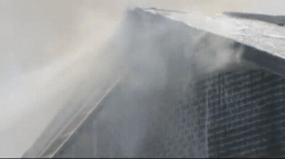 Tall Building With Smoke From Top GIF