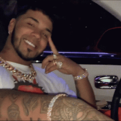 Tattooed Man In Car With Hand On Chin GIF