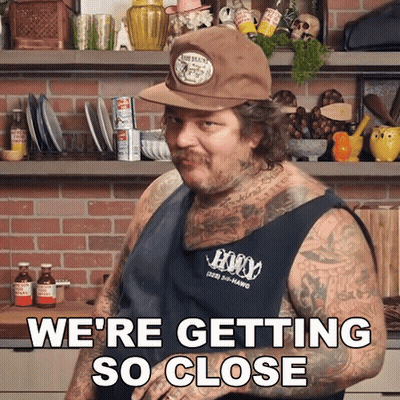 Tattooed Man In Hat And Tank Top Saying We're Getting So Close GIF