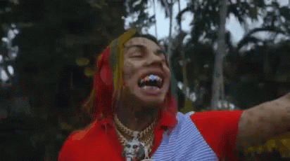 Tattooed Man Laughing In Front Of Trees GIF