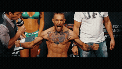 Tattooed Man Standing In Front Of Bikini Woman And UFC Shirt Man GIF