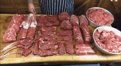 Tattooed Person Standing By Meat Table GIF