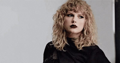 Taylor Swift In Black Shirt And Black Lipstick With Curly Hair GIF