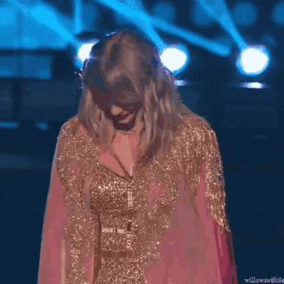 Taylor Swift In Pink And Gold Dress Smiling On Stage GIF